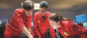 Three employees reviewing plans