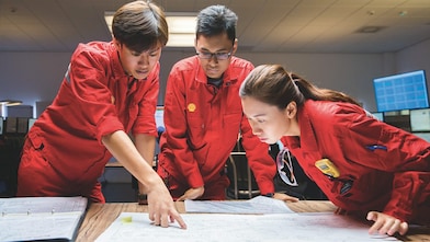 Three employees reviewing plans