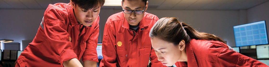 Three employees reviewing plans