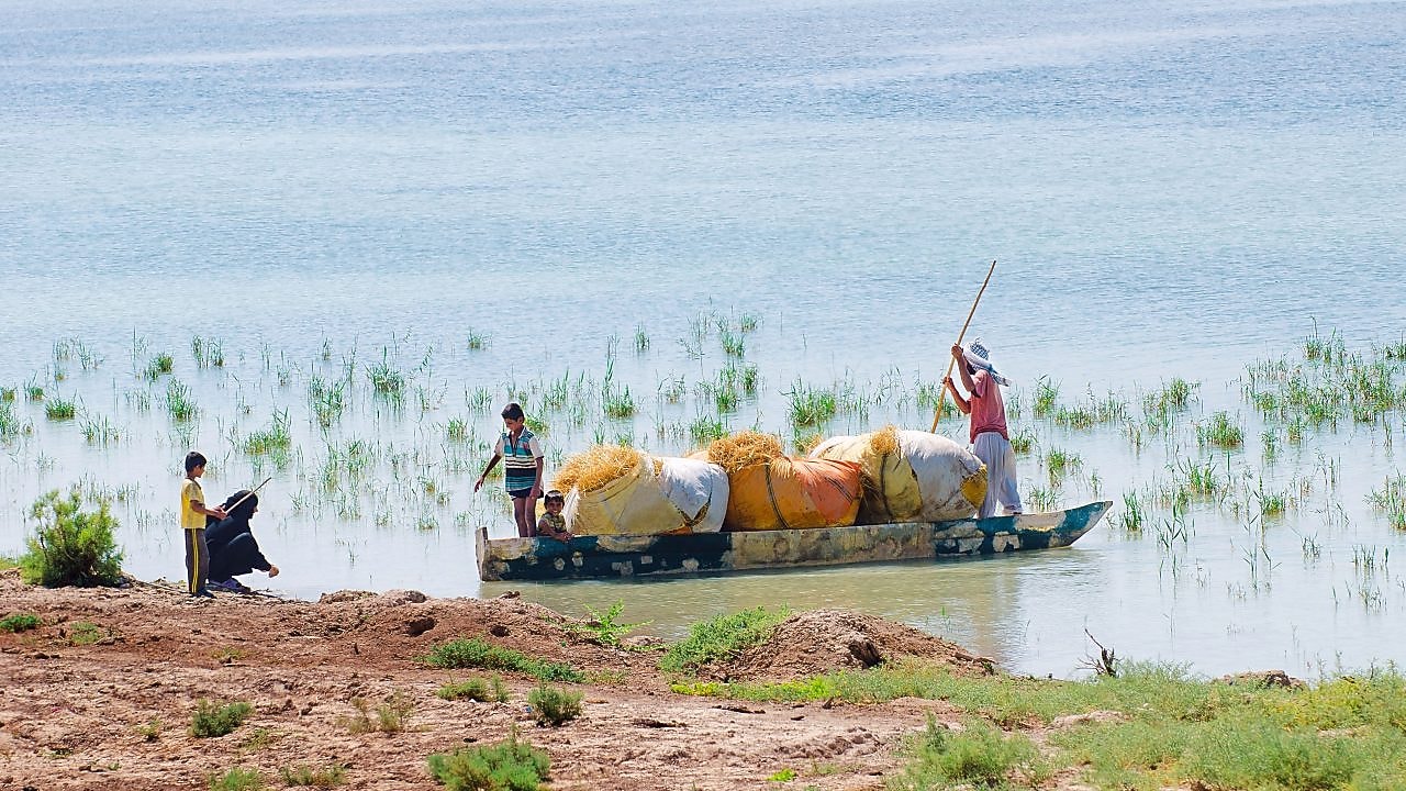 Local people cross the flooded Hawizeh Marshes, near the Majnoon project in Iraq