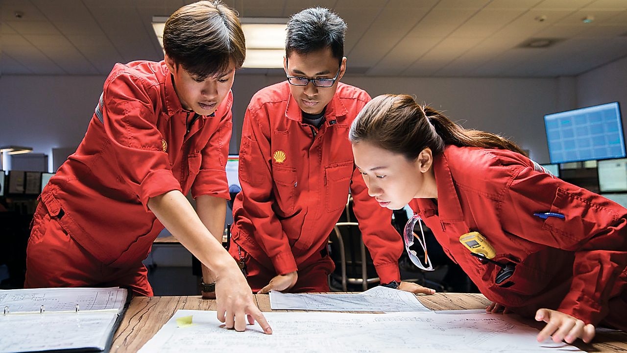 Three employees reviewing plans