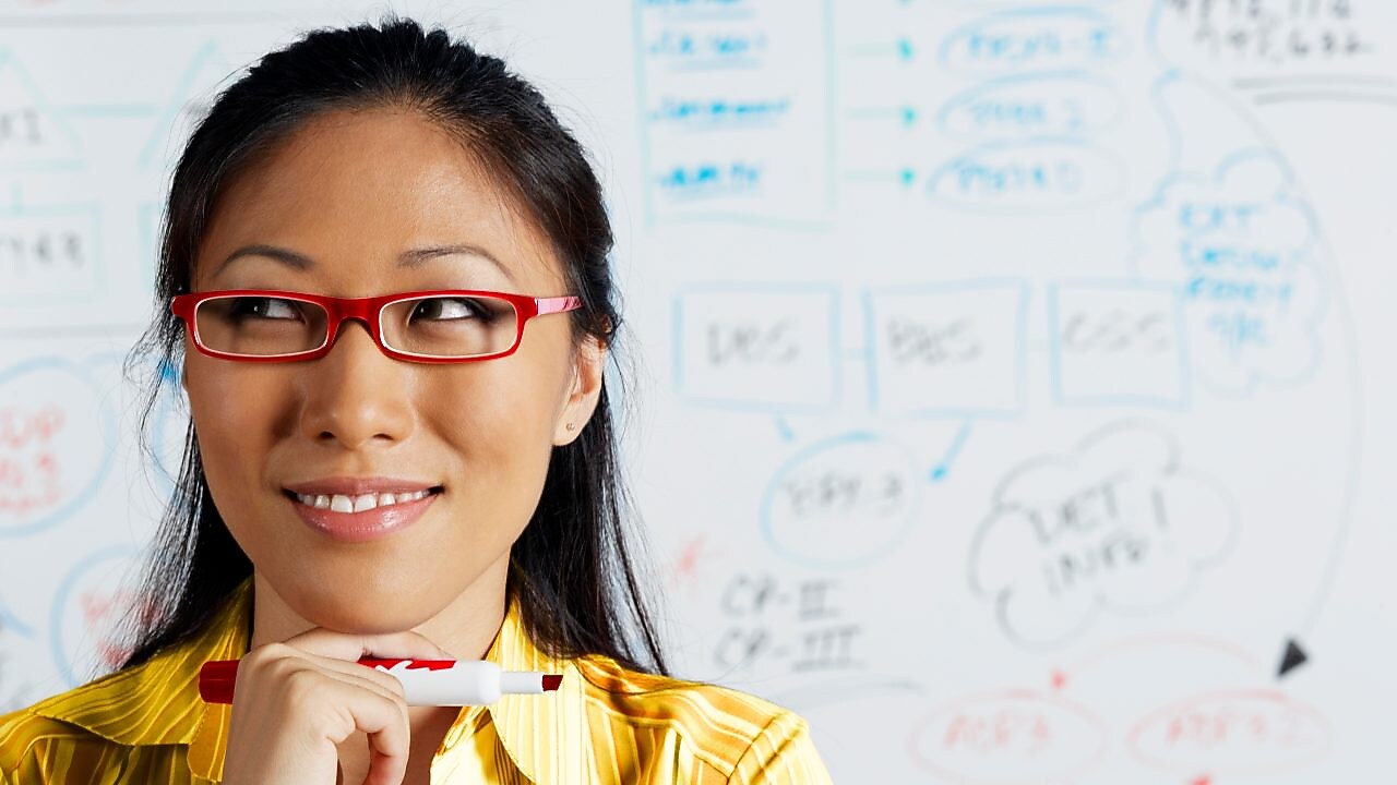 Close up of Asian businesswoman smiling in front of whiteboard