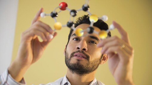 Young man examining molecular model