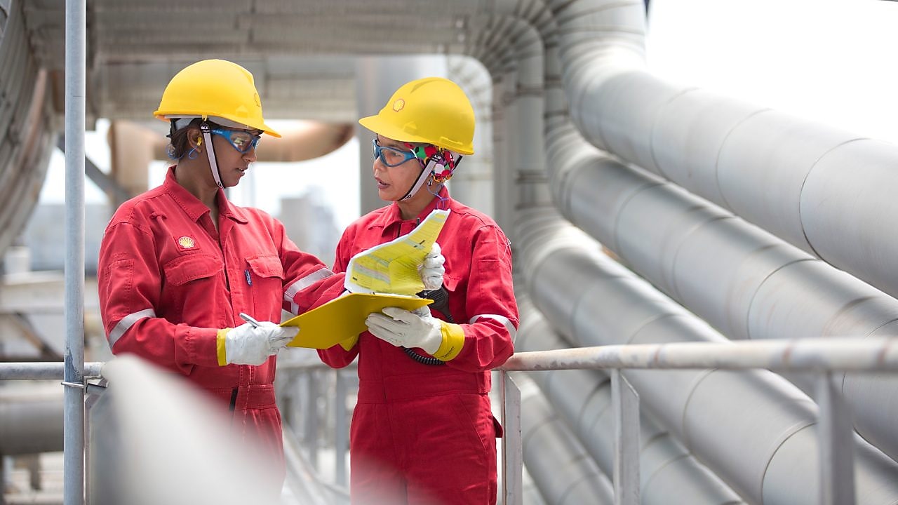 two workers discussing a project in a refinery in Malaysia