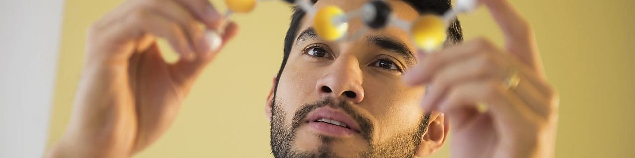 Young man examining molecular model