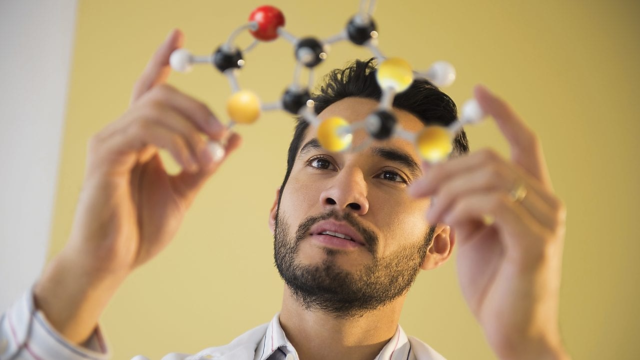 Young man examining molecular model