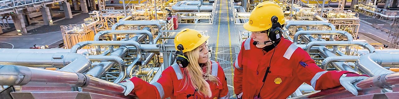 Two shell employees talking at work site
