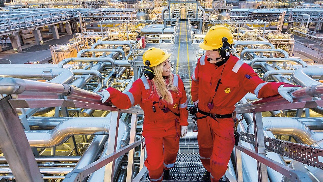 Two shell employees talking at work site
