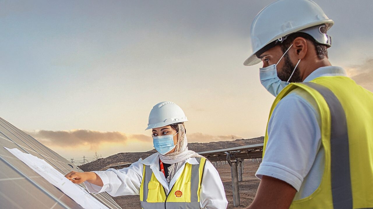 Two man standing near solar panel