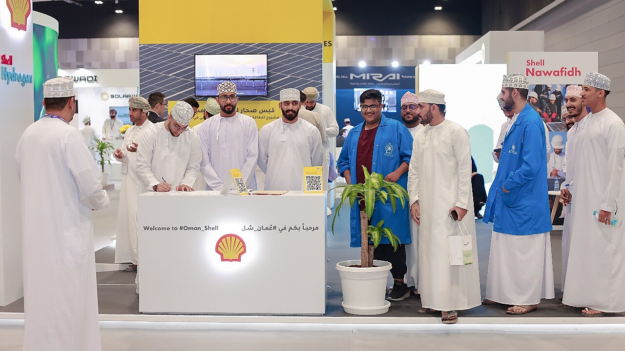 A group of people interacting at Oman Shell stand